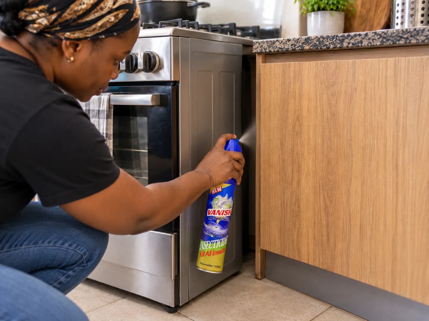 An aerosol can held at arm's length, directed into a gap behind a unit